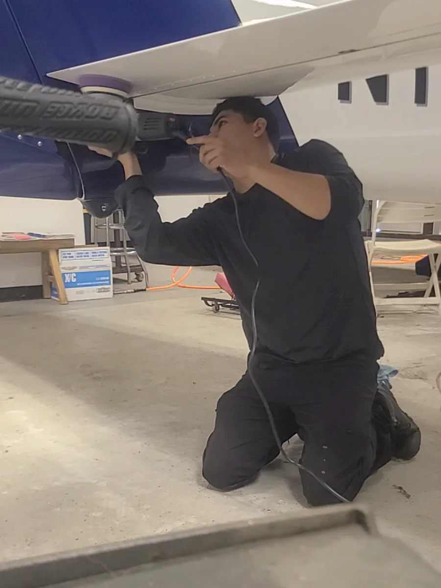 Joel Espiritu, owner of JJ Detailing Direct, detailing an aircraft wing
